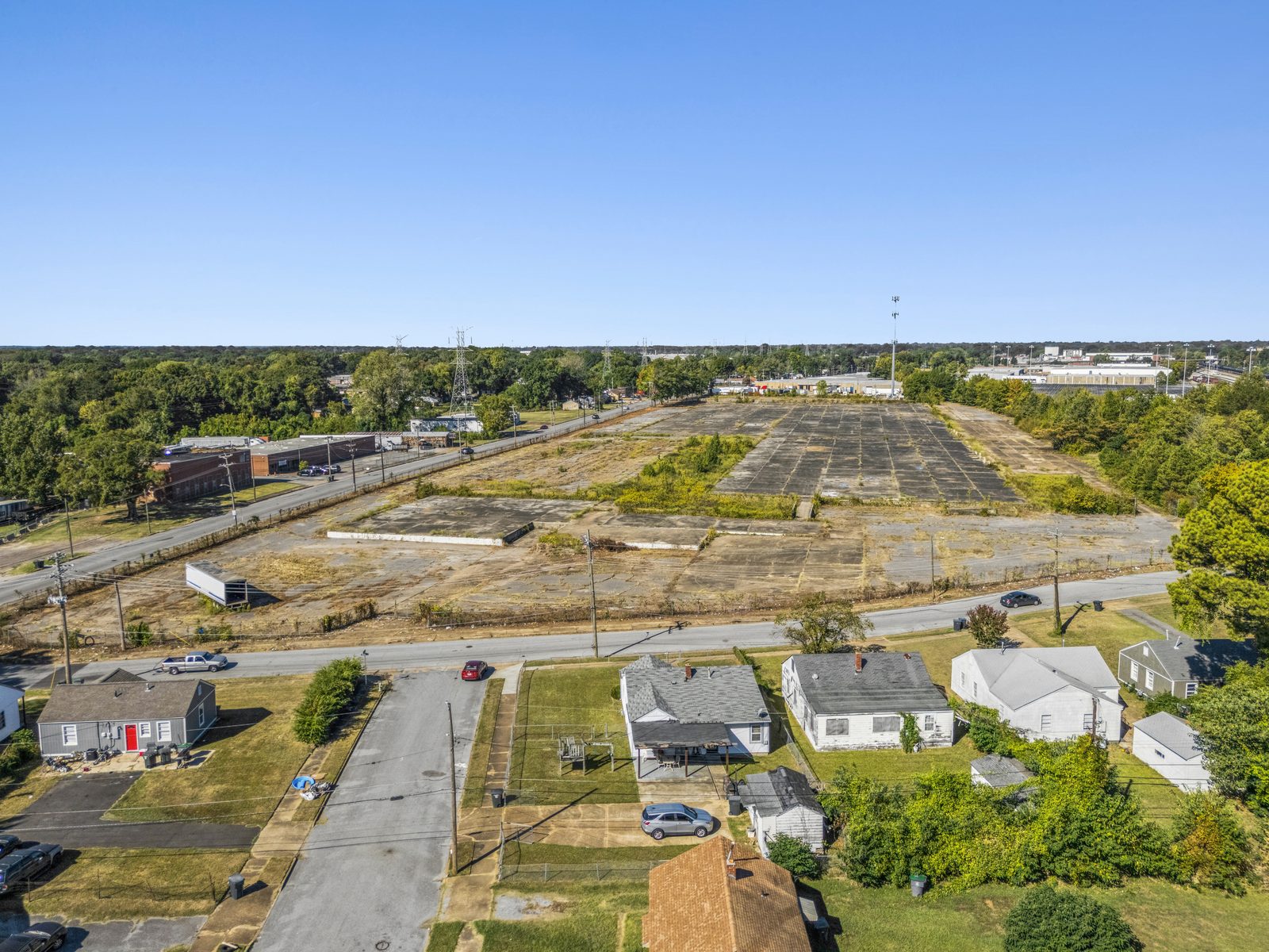 Aerial from above the houses across the street, looking over the road to the length of the concrete pad.