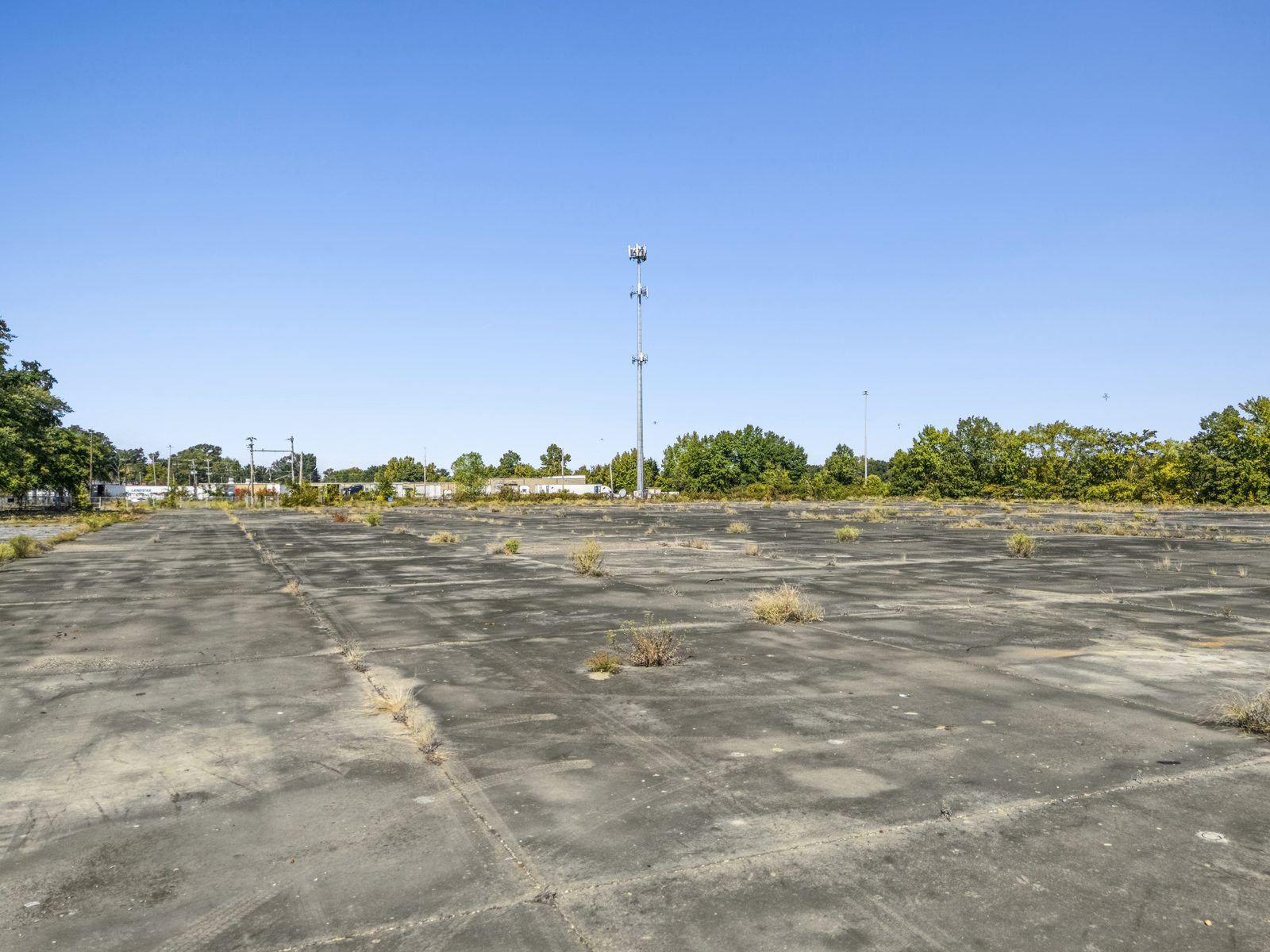 Ground view across the open concrete slab, with a light pole in the distance.