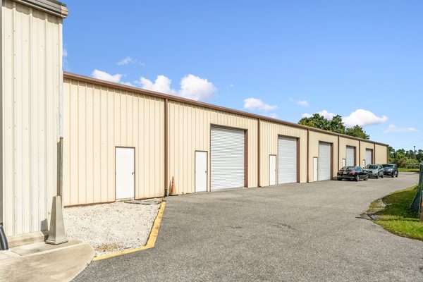 A multi-tenant small bay flex building with a run of roll-up doors and a shared drive aisle