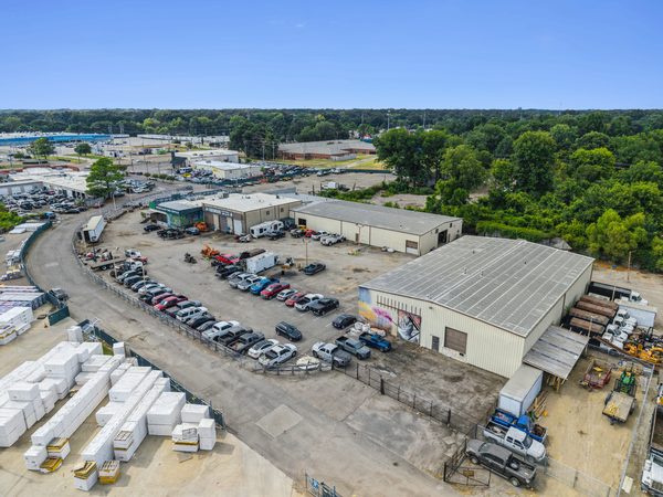 An industrial outdoor storage yard with trucks, trailers and equipment on graded hardstand