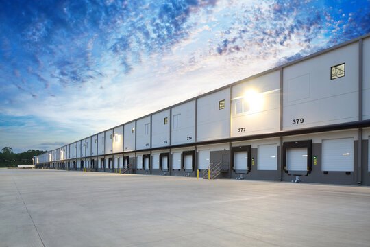 A long run of loading docks along a distribution warehouse at dusk